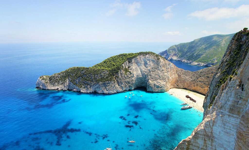 Stunning aerial view of Navagio Beach in Zakynthos, Greece, featuring turquoise water and a sunken ship.