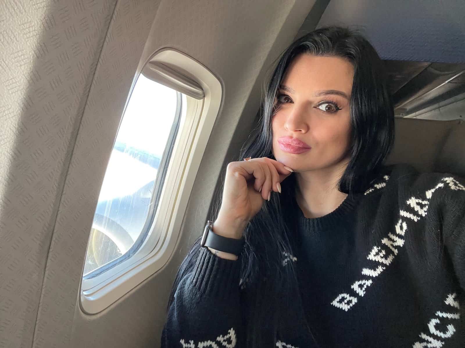 Traveler sitting on a plane seat preparing for a flight, demonstrating smart airport hacks for smoother travel.