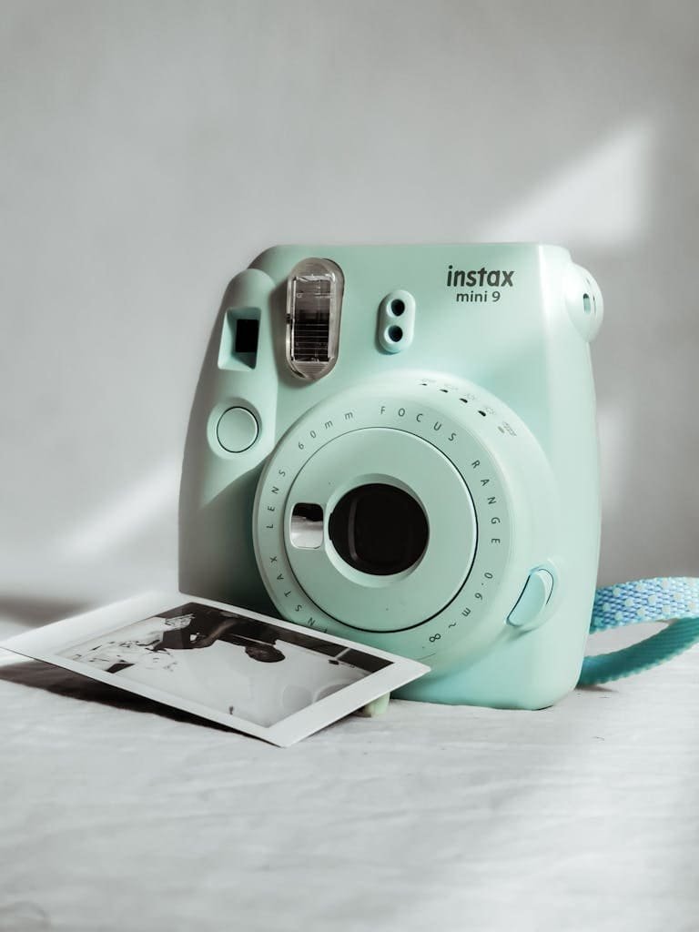 Mint green Instax Mini 9 instant camera with a printed photo.