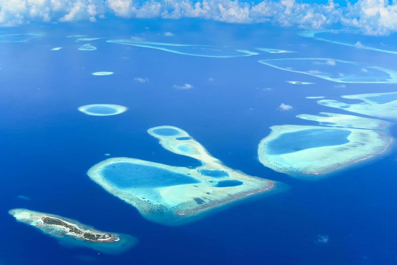 A breathtaking aerial view of the Maldives' turquoise atolls surrounded by deep blue ocean. Natural Wonders